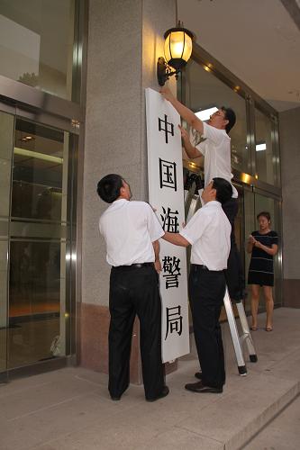 重组后的国家海洋局挂牌 中国海警局同时挂牌 7月22日清晨,工作人员在悬挂中国海警局的门牌。 7月22日清晨,位于北京复兴门外大街的国家海洋局门口,重组后的国家海洋局正式挂牌。与此同时,已悬挂14年的“中国海监总队”牌匾被取下,换上了崭新的“中国海警局”牌匾。 新华社记者 罗沙摄