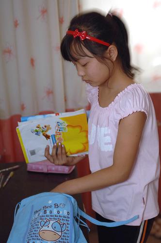 8月31日,略阳县高台小学学生袁文静在整理书包,为次日开学做准备。陕西省地震重灾区略阳县23000多名中小学生将于9月1日开学。 新华社记者丁海涛摄