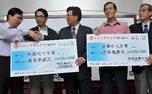 5月13日,中央政府驻港联络办副主任周俊明(中)与香港工会联合会及香港海员工会代表在支票递交仪式上。当日,香港多个团体通过中联办递交捐款,协助四川地震灾区抗灾救灾工作。 新华社记者 吕小炜 摄