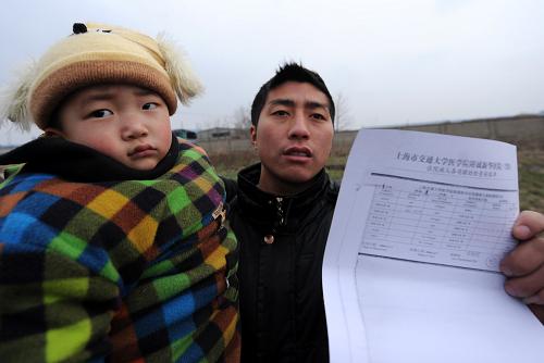 1月5日,束方林的父亲在展示检查报告。江苏省大丰市经济开发区河口村3岁儿童束方林(左)血液中铅含量为每升364微克,而儿童血铅的正常范围为每升0——100微克。 位于江苏大丰经济开发区的河口村共有16岁以下常住儿童132人,其中110人最近接受了血液检查,根据1月3日该市政府对外宣布的数字,他们中有51人血铅含量超标。大丰市相关部门表示:将对患儿实施妥善治疗,责令企业限期搬迁,由市纪委、监察局牵头成立调查组,实施责任追究。 新华社记者姜帆摄