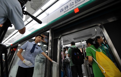 7月19日,地铁奥运支线的乘务员引导记者进入车厢。当日上午,在京媒体记者抢先体验即将于下午正式开通的北京地铁奥运支线。北京地铁奥运支线位于北京市南北中轴线下,奥林匹克中心区内,全线共设4座车站,是惟一直接进入奥运中心区的地铁线路。 新华社记者 李文摄