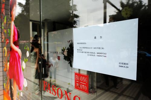 5月29日,二代病例患者工作的广州市某婚纱影楼大门上张贴着暂时停业通告。 新华社记者 刘大伟 摄