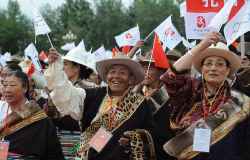 6月21日,当地藏族群众沿途欢迎奥运圣火。当日,北京奥运会圣火传递活动在西藏拉萨举行。 新华社记者索朗罗布摄