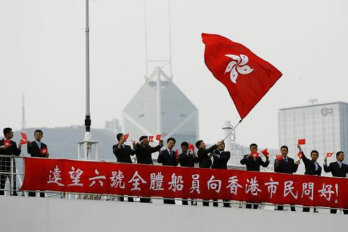 4月29日,“远望六号”抵达香港时,船员摇动香港特区区旗并打出问候标语。 新华社记者 周磊 摄