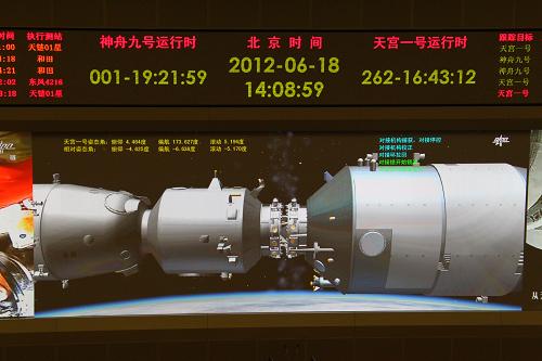 6月18日拍摄的北京航天飞控中心大屏幕显示的神九飞船与天宫一号交会对接的画面。 新华社记者查春明摄