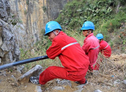 3月26日,在广西百色市凌云县伶站瑶族自治乡岩流瑶寨,工作人员在帮助村民从100多米的山谷中引水。长时间干旱给广西13个市、85个县(市)带来严重影响。面对严重的旱情,旱区社会各界积极投入到抗旱救灾中,携手共渡难关。新华社记者 周华 摄