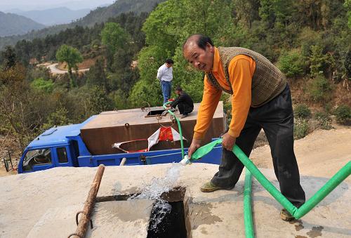3月26日,在广西百色市凌云县伶站瑶族自治乡陶化村,送水车在向水窑注水。新华社记者 周华 摄