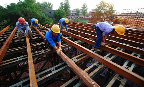 4月24日,在江西九江新长江大桥施工现场,工人在调整浇注桥梁的支架。新华社发(胡国林 摄)