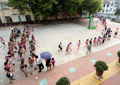 9月8日,南丰县莱溪乡中心小学的学生们放学回家。 近年来,随着农村经济的发展,农民对子女的期望值增加,学生择校特别是进城借读情况愈演愈烈,导致农村中小学生源大量流失,出现一大批“超小”的农村中小学和几个“超大”规模的县城学校。为优化教育资源配置,推进城乡教育均衡发展,江西南丰县从2009年开始,实施教育向上集中工程,将全县初中学校向县城及部分中心镇集中,农村小学向乡镇所在地及中心村集中,实施城乡联动,分步推进。目前,全县共建有3所“九年一贯制”学校,22所农村中小学实行了寄宿制。新华社记者周科摄