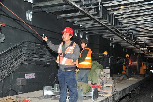 12月12日,中铁电气化局集团一公司建设者在北京轨道交通14号线大瓦窑至园博园区段进行接触网导线架线作业。新华社发(李朝臻 摄)