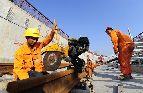 西安地铁一号线轨道工程即将全线贯通 8月28日,施工人员在西安地铁一号线进行锯轨对接作业。 由中铁十一局三公司等单位施工的西安地铁一号线轨道工程目前进入最后收尾阶段,将于8月29日全线贯通。 西安地铁一号线一期工程将支撑西安东西向拓展的城市发展格局,是西安轨道交通线网中的骨干线路。线路不仅局部穿越明城墙等国家级重点文物保护单位,施工中的8次小角度斜穿5条地裂缝也成为工程实施的难点。自铺轨以来,中铁十一局等施工单位克服了工期紧、施工跨度大、交叉作业多、协调面广等诸多难点和风险,10次下穿5座立交桥,并下穿古城墙、护城河老桥及两条河流,按期实现工期节点目标。 西安地铁一号线一期工程全长25.36公里,于2009年3月底全线开工。轨道工程全线贯通后,西安市地铁一号线一期工程将于年底实现全线电通,预计明年9月通车试运营。 新华社记者 郝同前 摄