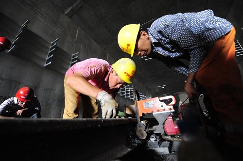 8月28日,施工人员在西安地铁一号线进行钢轨对接作业。 由中铁十一局三公司等单位施工的西安地铁一号线轨道工程目前进入最后收尾阶段,将于8月29日全线贯通。 西安地铁一号线一期工程将支撑西安东西向拓展的城市发展格局,是西安轨道交通线网中的骨干线路。线路不仅局部穿越明城墙等国家级重点文物保护单位,施工中的8次小角度斜穿5条地裂缝也成为工程实施的难点。自铺轨以来,中铁十一局等施工单位克服了工期紧、施工跨度大、交叉作业多、协调面广等诸多难点和风险,10次下穿5座立交桥,并下穿古城墙、护城河老桥及两条河流,按期实现工期节点目标。 西安地铁一号线一期工程全长25.36公里,于2009年3月底全线开工。轨道工程全线贯通后,西安市地铁一号线一期工程将于年底实现全线电通,预计明年9月通车试运营。 新华社记者 郝同前 摄