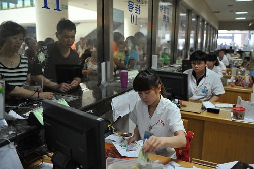 9月7日,江西省儿童医院医务人员在挂号窗口忙碌。 9月3日起,江西省儿童医院在江西省内第一个取消与中介机构合作,在官网、医院门诊和住院部显眼位置公布预约电话和预约方式,仅4日一天就为40多名患者安排看病时间。据了解, 中介机构提供预约诊疗服务多为有偿服务,这笔费用虽然不多,但确实是患者看病之外的额外负担,卫生部门将一边建设和完善全省统一的预约平台,一边鼓励医院提供免费预约服务。 江西省卫生厅2011年着手建设全省统一预约诊疗服务平台,联合多家电信运营商,开发了集约式预约诊疗服务平台和12320呼叫中心,逐步取代原有的预约中介机构。 新华社记者周密摄