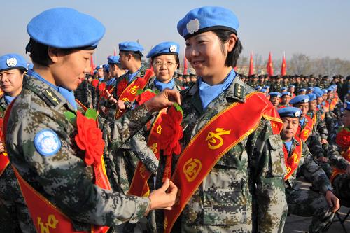 11月27日,在驻陕西某部队营区,两名赴刚果(金)的维和官兵医疗分队的女队员在相互整理服装。新华社发(武国强 摄)