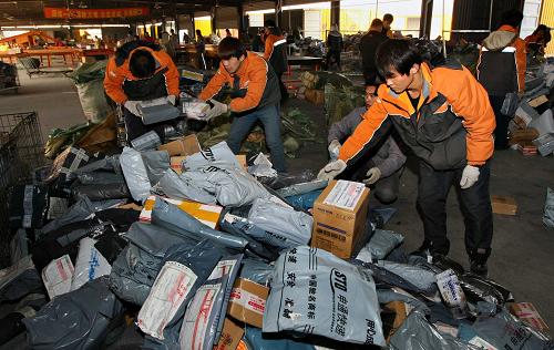 12月12日,快递员在江苏省南通市一家快递公司的派送件现场分拣快件。新华社发(徐培钦 摄)