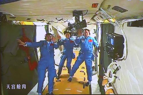 2012年6月18日拍摄的北京航天飞控中心大屏幕显示的航天员景海鹏、刘旺、刘洋在天宫一号实验舱内的画面。新华社记者 查春明 摄