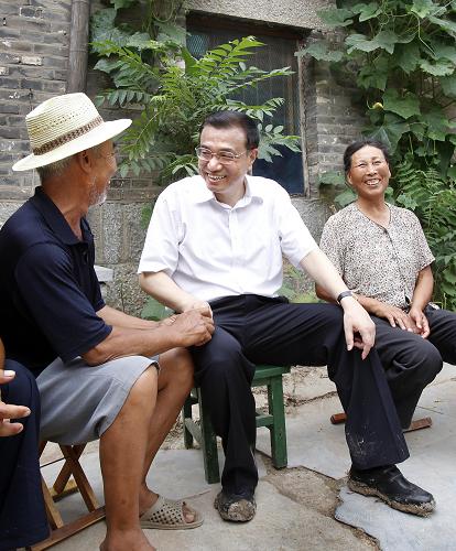 2010年7月8日,李克强在山东济宁市嘉祥县大孙村与贫困户孙树节一家亲切交谈。新华社发