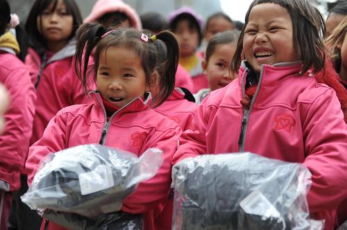 这是12月19日,在贵州省黔南布依族苗族自治州罗甸县董王乡打改小学,孩子们穿上“爱心衣橱”发放的新衣服。“爱心衣橱”公益活动由媒体从业者倡议发起,倡议由演艺界、传媒界等爱心人士捐出戏服、出镜装、礼服、演出服等,通过线上和线下的拍卖、义卖的方式筹得善款,为贫困地区的孩子们购买衣物。新华社发(陶亮 摄)