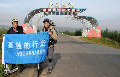 “孤独的行走——为贫困自闭症儿童募捐公益活动”的发起者窦一欣(右)和陈萌在黑龙江省漠河县出口处合影(8月27日摄)。爱心人士窦一欣和自闭症青年画家陈萌于今年8月25日发起“孤独的行走”为贫困孤独症儿童募捐活动,计划从黑龙江省北极村一路向南,徒步或利用滑板车行进7000公里,跨越11个省份到达海南。 新华社记者王凯摄