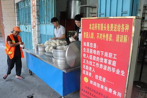 在福建省石狮市的曾坑社区,有一家“只送不卖”,名为“永恒阳光”的馒头店。店里的爱心人士将做好的馒头免费送给下岗职工、贫寒家庭、流浪者和拾荒者等(8月21日摄)。新华社记者郭圻摄