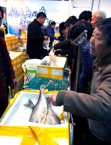 1月26日,许多顾客在钓鱼岛鲜鱼摊位上挑选深海鱼。新华社记者 陈飞 摄