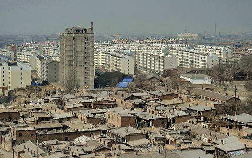 在内蒙古包头市东河区北梁棚户区的旁边是大片正在建设的用来安置棚户区迁出居民的保障房。(2月26日摄)。内蒙古包头市东河区北梁棚户区是包头市面积最大、最典型的城市棚户区,占地13平方公里,有居民4.7万户、12.4万人,人均住宅面积不足15平方米,其中70%以上的居民无固定收入,北梁地区的住房90%以上为超过50年的土木结构危旧房屋。近年来,当地开始陆续建设改造房,已对北梁棚户区1.13平方公里的核心区实施了改造,完成总投资20.8亿元,安置北梁棚户区核心密集区居民1.02万户,3.06万人受益。为改善更多棚户区居民的居住环境,2011年起,当地规划实施各类保障性住房345万平方米,目前已开工建设114.04万平方米,预计2013年可竣工100万平方米,安置居民1.25万户。新华社记者 赵婷婷 摄