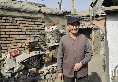 2月26日,一位在北梁棚户区生活50多年的老人在住房前。他在等待搬迁安置。新华社记者 赵婷婷 摄