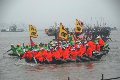 4月5日,在江苏溱潼会船节上,参加比赛的选手们奋力划桨。 新华社发(封疆江 摄)
