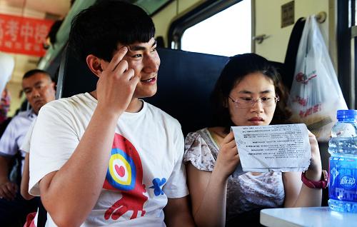 6月5日,L7061次“高考学生专列”上,内蒙古鄂伦春自治旗大杨树镇二中的考生黄剑锋(左)在姐姐黄萍(右)的帮助下背诵生物知识。黄剑锋来自安徽芜湖,他希望能学习医学专业,将来像姐姐一样从事牙医的工作。新华社记者 王凯 摄
