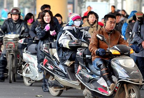 几位郑州市民骑电动车赶路(2009年12月2日摄)。 日前,国家四部委联合下发《关于加强电动车管理》通知,要求各省依照现有规定限期淘汰时速达30公里以上的在用“超标”电动车,并按照现有标准整改电动自行车产业。 消息一出,让原本就处在机动车与非机动车“夹缝”中尴尬生存的电动自行车再次成了众人瞩目的焦点。据郑州市交管部门统计,目前郑州市的电动自行车已超过50万辆,其中时速超过30公里的“电摩”占绝大多数。电动车车速的“超标”,加之驾车人交通意识淡薄,已成为城区交通事故主要诱因。但由于“打击面”太大,交警部门对电动车超速行驶这种交通违法行为,也很难逐个治理。 另有资料显示,目前全国电动车的拥有量已超过1亿辆,如果按照新国标执行,不仅大部分电动车将在新规则下成为废品或“黑户”,更涉及数以千计的企业生存及行业的发展。新华社记者 王颂 摄
