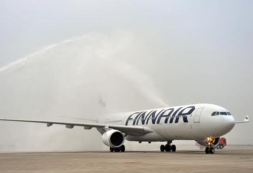 5月10日,芬兰航空首航重庆的空客A330客机通过重庆江北国际机场清洗飞机机体的水幕。新华社记者 刘潺 摄