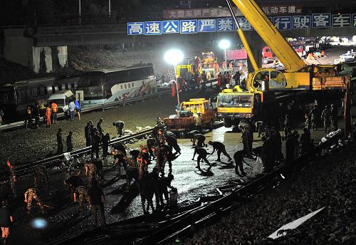 7月24日凌晨,抢险人员在清理高速公路上的淤泥。新华社记者 李文 摄