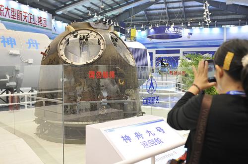 “嫦娥”“天宫”齐亮相 一位观众正在用手机拍摄珠海航展上展出的神九返回舱实物(11月14日摄)。 11月14日,在第九届中国国际航空航天博览会航天馆内,神九返回舱实物、天宫神九对接组合体模型、嫦娥三号月球车模型等重量级展品亮相,吸引了众多观众的目光。 新华社记者梁旭摄