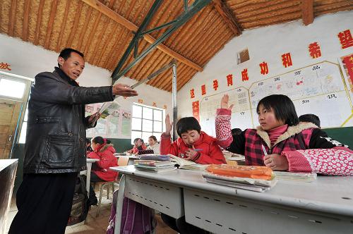 生态移民的第一个“暖冬” 12月26日,在移民村的学校里,孩子们在上课。 时值寒冬,素有“贫瘠甲天下”之称的宁夏西海固大地刚刚经历了2012年最寒冷的日子,田地里处处覆盖着薄薄的积雪,记者来到位于西吉县震湖乡的孟湾移民新村,刚刚从大山深处搬迁到这里的100余户移民将度过他们搬迁后的第一个冬天。 孟湾村是一个以劳务输出为特点的移民村,村里家家户户的青壮年劳动力基本都外出务工,村里的村民以妇女、儿童和老年人为主。在村民史腊月宽敞明亮的新居中,卧室门边已经挂上了迎接新年的红辣椒装饰,史腊月和几位邻居正在炉子边烤火聊天,进入冬季之后,搬迁来的移民家家户户都领到了冬季取暖用的新炉子和1吨煤。史腊月的儿子正在村里的移民点小学上课,虽然离家很近,但是因为中午学校有免费午餐,所以她儿子每天中午都留在学校吃午饭,“他总说学校的饭更香!”史腊月笑着说。 眼下正是农闲时节,在村里,记者走访了好几户,都没有看到村民们聚在一起打牌喝酒,反而在村部的农家书屋内,记者见到了几位正在翻阅牛羊饲养方式书籍的村民,一位村民告诉记者,到明年,他家就要开始收拾牛棚养肉牛了,所以来搜集点