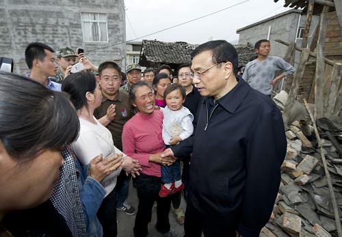 李克强在震区24小时的足迹 4月20日下午,国务院总理李克强来到芦山地震重灾区双石镇,看到李克强,村民们纷纷围拢过来,向他讲述地震时的情景和家里受灾情况。 新华社记者 黄敬文 摄