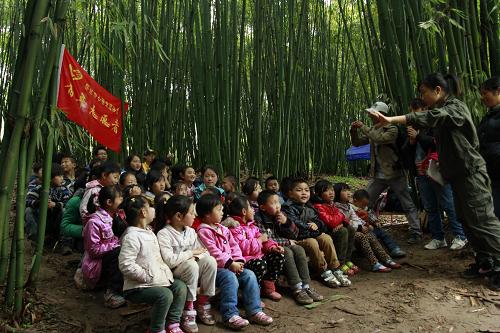 孩子,我爱你 4月24日,在四川省雅安市芦山县龙门乡王家村石刀背沟组的“竹林教室”,志愿者带着孩子们上音乐课,以缓解他们的紧张情绪。 4月28日是世界儿童日。芦山地震灾区的孩子们,祝福你们。 新华社发(周强 摄)