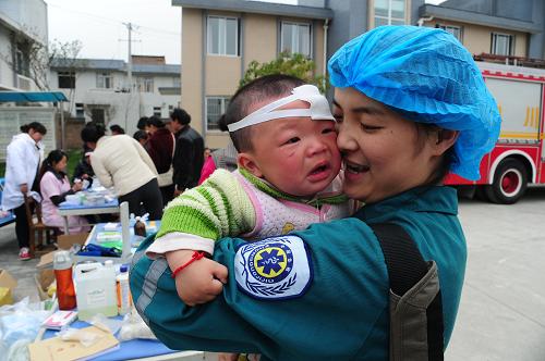 芦山瞬间:呵护 4月21日,芦山县龙门乡,绵阳市第三医院的医护人员在照顾地震中受伤的一名8个月大的孩子。 新华社发(何海洋 摄)