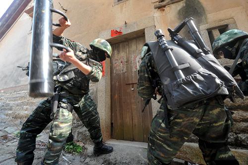 厦门武警特战队举行城市反恐实战演练 厦门武警特战队员使用撞门器对藏匿“恐怖分子”的房屋大门实施破拆(1月5日摄)。 1月5日,福建厦门武警特战队在厦门市湖里区五通浦口社区举行代号为 “2014-西岸鸣镝”的城市反恐实战演练,通过侦查、排爆、破拆等课目的训练,提高特战队员实战能力。 新华社记者彭张青摄