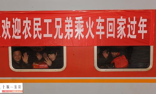 1月27日,几名返乡农民工透过车窗向送行人群挥手道别。新华社记者 何俊昌 摄