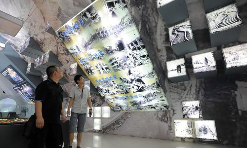 7月28日,市民在天津滨海防震减灾科普教育基地观看地震灾害图片。新华社发(兰翔雁 摄)