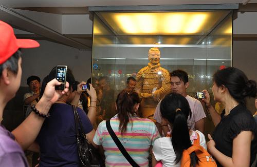 兵马俑二号坑的展台边挤满了游客(8月10日摄)。进入旅游旺季,享有“世界第八大奇迹”的秦始皇兵马俑博物馆天天游客爆满,日游客量少则1.5万人次以上,多则近3万人次,整个博物馆人满为患。据馆内工作人员介绍,因暑期和西安世园会的举办,参观兵马俑的游客超出去年同期60%,创下历史新高。高温的蒸烤,毫无控制的游客人流,如此长久下去,即使是铁打的“兵马俑”也难堪重负。记者建议,为了世界文化遗产,也为了有一个满意的旅游心境,游客们不妨错开旅游高峰,再到兵马俑一游。新华社记者 陶明 摄