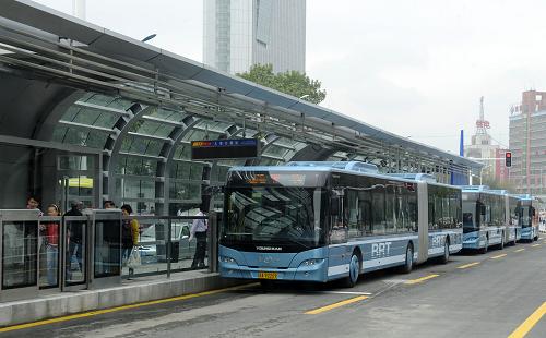 8月28日,几辆BRT快速公交车停靠在站台旁上下乘客。当日,乌鲁木齐市大容量快速公交系统正式启动,并投入运营。被称为BRT的大容量快速公交系统(Bus Rapid Transit),是一种介于快速轨道交通与常规公交之间的新型公共客运系统,通常被称作“地面上的地铁系统”。为改善乌鲁木齐的交通拥挤,提高出行效率,乌鲁木齐今年投资9.3亿元,兴建了3条BRT快速公交路线。投入运营车辆达96辆,全程票价为1元。新华社记者 王菲 摄