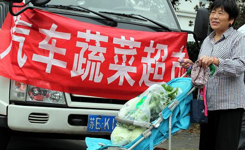 10月13日,在苏州市城北街大观名园社区,社区居民推着婴儿小推车在汽车蔬菜超市购买新鲜蔬菜。当日,在苏州市物价局牵线搭桥下,太仓绿润农副产品基地在苏州市城北街大观名园社区,首次以汽车蔬菜超市直销农产品模式进社区试点销售,近3吨安全、绿色农产品价格平均降幅超过三成以上,受到居民热烈欢迎。此举将在苏州市各社区逐步定期展开。新华社发(李俊锋 摄)