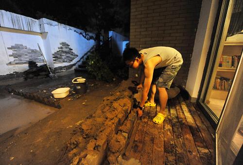 7月30日,银川市凯威观湖壹号小区内,家住一楼的居民在门外搭建防水堤。 新华社记者 彭昭之 摄