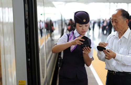10月16日,服务员在合肥火车站为即将登上合肥至北京南G262次列车的旅客服务。新华社记者 刘军喜 摄