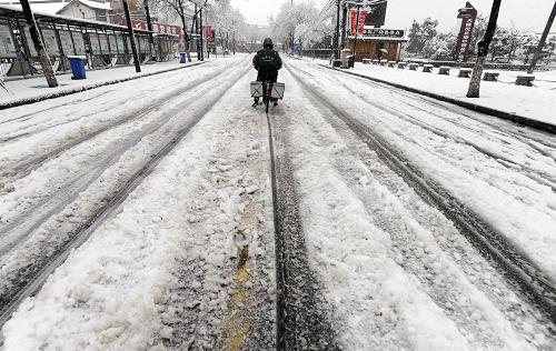 2月19日,骑车人在江苏苏州街头冒雪骑行。新华社发(杭兴微 摄)