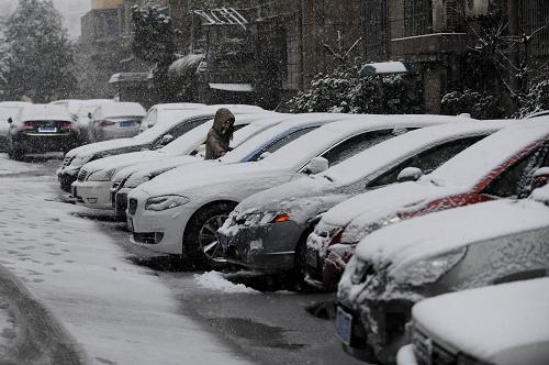 2月19日,一位杭州市民在清理车辆上的积雪。新华社记者 鞠焕宗 摄