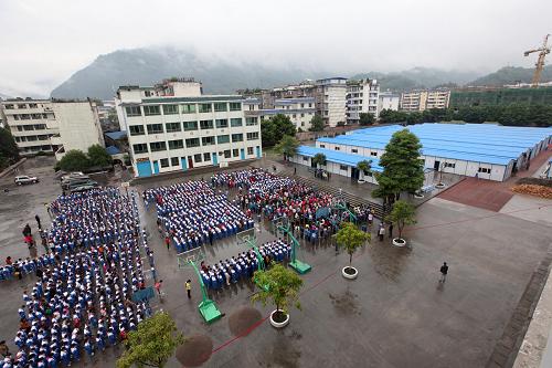 5月2日,在四川省雅安市天全县城区第一完全小学,学生们课间在操场上举行复课典礼。当日,四川省雅安市天全县第一完全小学在板房内全面复课。天全县第一完全小学有6个年级,共40个班,2502名学生,是天全县规模最大的小学。地震中该校教学楼成为危楼,共青团湖南省委和湖南省青少年发展基金会联合白沙飞翔公益基金等共同捐建了49间板房,保障全校师生上课和办公的需要。新华社发(张晓理 摄)