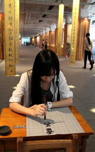 9月4日,一名参观者在“汉字艺术节”上练习毛笔书法。新华社记者 樊浩宇 摄