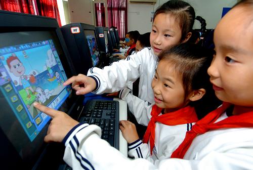 2007年11月21日,在厦门市江头第三小学就读2年级的四川籍外来工子女袁云迪(中)在课堂上学习电脑制图。厦门市将农民工子女义务教育纳入辖区教育发展规划,逐年增加进城务工的农民工子女公办学校的数量,扩大招生规模,有效地解决进城务工农民工子女入学难问题。新华社记者 张国俊 摄